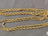 a close up of a gold chain on a gray surface
