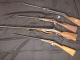 five guns are lined up on a black cloth on a table