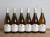 six bouteilles de vin sont alignées sur une table