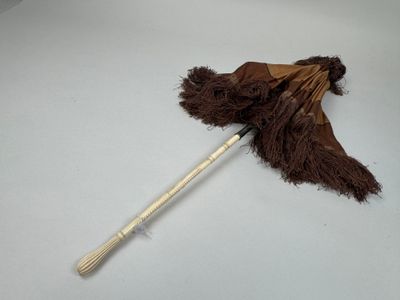 a brown umbrella with a wooden handle on a white surface
