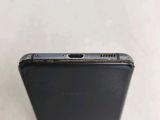 the back of a black cell phone with a small hole in it