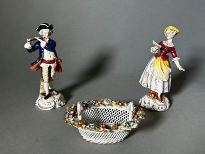 two figurines of a man and a woman standing next to each other