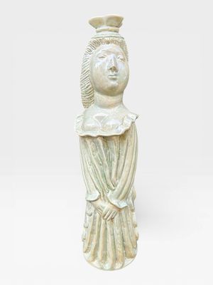 une petite statue représentant une femme coiffée d'un chapeau