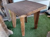 a small wooden table on the grass in front of a building