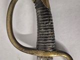 a close up of a sword on a white surface