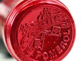 a close up of a red wine bottle with a crown on it