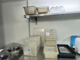 many containers and pans on the shelf in the kitchen