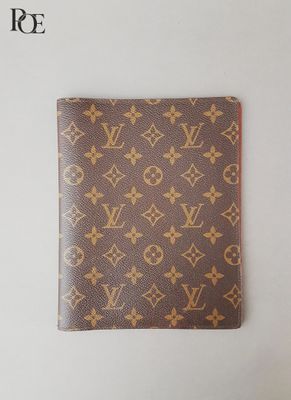 un portefeuille Louis Vuitton posé sur une surface blanche