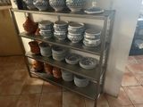 plusieurs assiettes et bols sur une étagère dans la cuisine