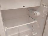 a white refrigerator with its door open on a tile floor