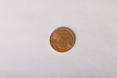a gold coin on a white surface with a white background