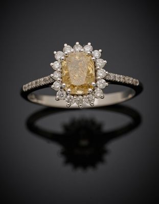une bague sertie d'un diamant jaune et blanc sur un fond noir