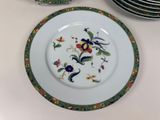 a plate with a floral design on it next to a stack of plates