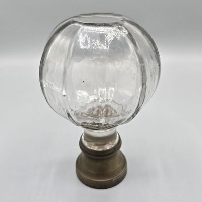 un gros plan d'un bouton en verre monté sur une base métallique