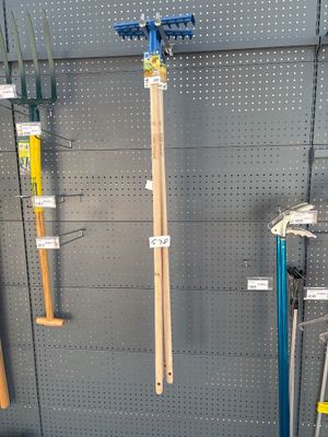 many different types of garden tools hanging on the wall