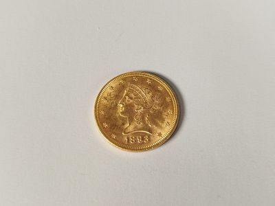 a close up of a gold coin on a white surface