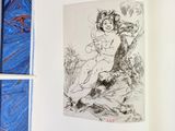 an open book with a drawing of a woman sitting on a rock