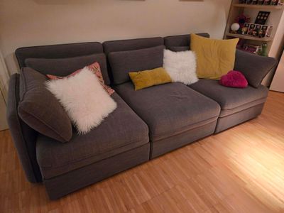 un canapé gris avec des coussins dans un salon