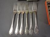 six forks and a knife are sitting next to a box of salt and pepper shakers