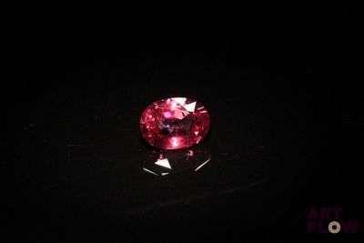a close up of a pink diamond on a black surface