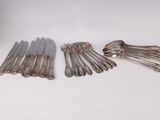 a lot of silverware on a white table