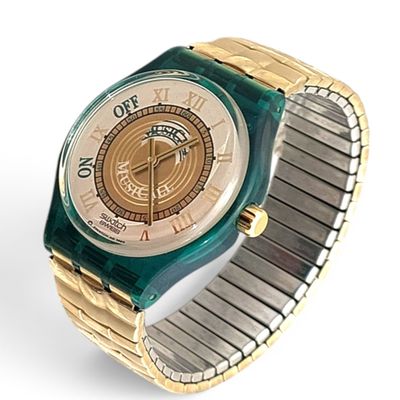 a gold and green watch with a white face