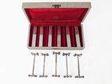 a wooden box with six silver spoons in it