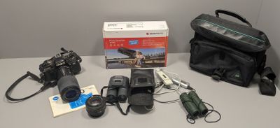 un appareil photo, un étui pour appareil photo, un sac et d'autres objets posés sur une table