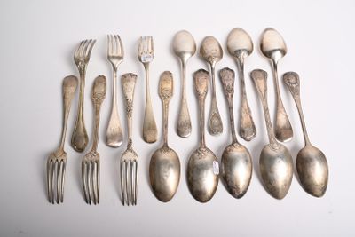 un grand nombre de cuillères et de fourchettes disposées sur une table