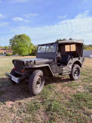 une vieille jeep garée dans l'herbe par une journée ensoleillée