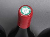 three bottles of red wine sitting on top of a table
