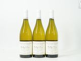 trois bouteilles de vin blanc sont alignées sur une surface blanche