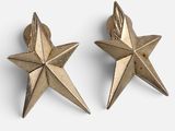 deux boucles d'oreilles en forme d'étoile dorée sur fond blanc