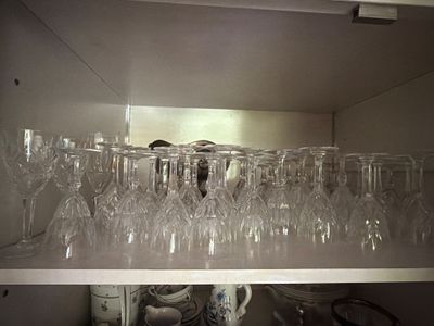 de nombreux verres à vin posés sur une étagère dans la cuisine