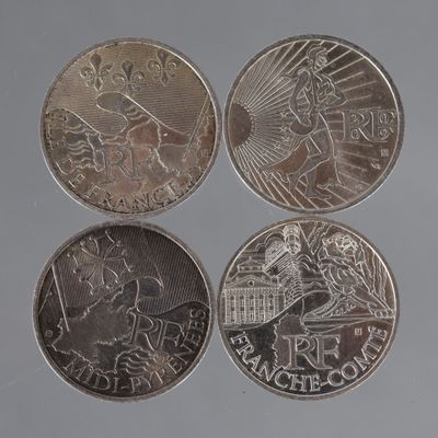 quatre types de pièces différents sont représentés sur une surface grise