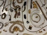 many different types of necklaces and bracelets laid out on a table