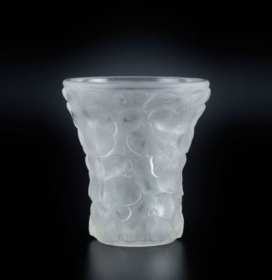 vase en verre translucide posé sur une surface noire, avec un fond noir