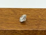 a close up of a single diamond on a wooden surface