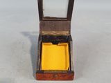 a small wooden box with a yellow cloth inside of it