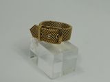 a close up of a gold ring on a clear glass block