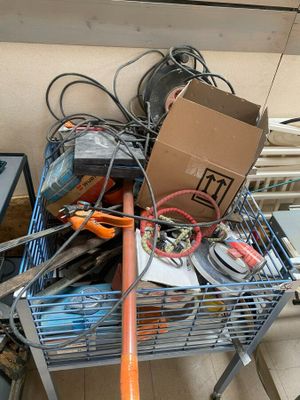 a cart full of assorted items and tools on the floor
