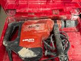 une image représentant une boîte à outils rouge contenant une perceuse et d'autres outils