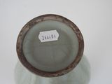 a white vase with a brown rim and a label on it