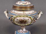 a blue and white vase with a lid on a stand