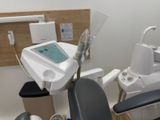 a dentist chair with a monitor in the corner of the room