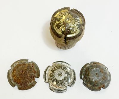 quatre morceaux de vieux métal posés sur une surface blanche