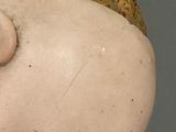 a close up of a doll head with a banana in it ' s mouth