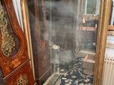 a large mirror sitting on the floor next to a grandfather clock