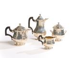 three pieces of silver tea and coffee set on a white surface