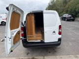 a small white van with its doors open in a parking lot